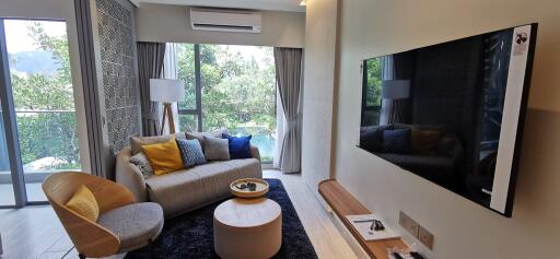 Modern living room with large windows and a flat-screen TV