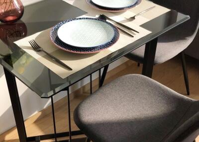 Modern dining table with two place settings and cushioned chairs