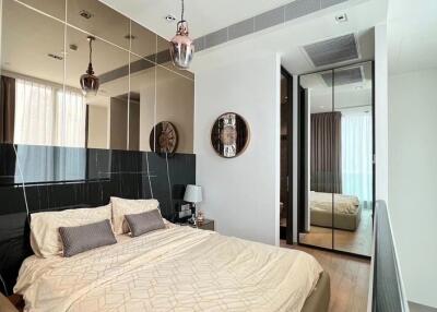 Modern bedroom with double bed, large mirror, and elegant decor