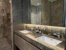 Modern bathroom with double sinks and a glass-enclosed shower