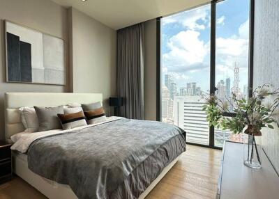 Modern bedroom with large windows and a city view