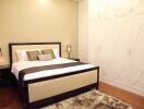 Modern bedroom with double bed, lamps on bedside tables, large wardrobe, and carpet