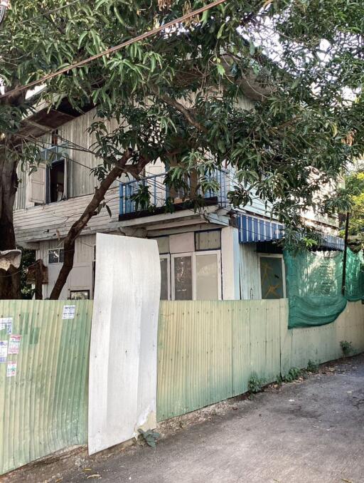 Aged exterior of a residential building with surrounding greenery