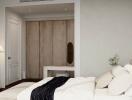 A modern bedroom with a neutral color scheme, featuring a bed, wall-mounted TV, and wooden closet