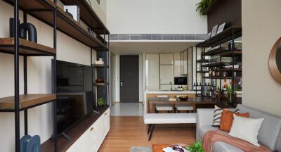 Modern living room with shelving and kitchen view