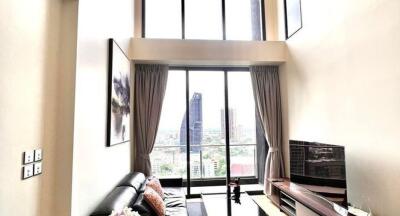 Spacious living room with tall windows and city view