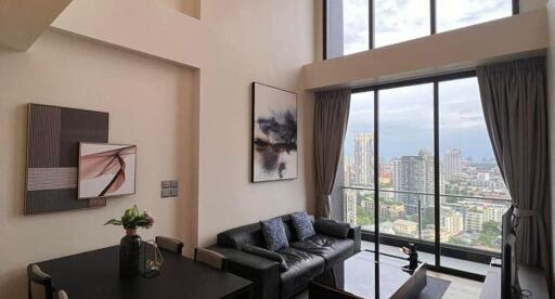 Spacious living room with large windows offering city views