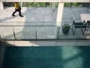 Outdoor swimming pool with a glass railing and seating area