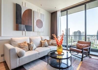 Modern living room with a comfortable sofa, armchair, coffee table, and a large window with a city view