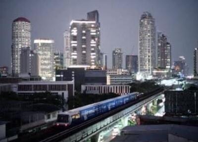 Nighttime cityscape view with skyscrapers and a train