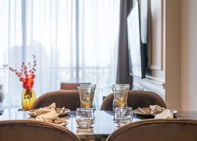 Elegant dining area with a table set for four, adjacent to a cozy living room