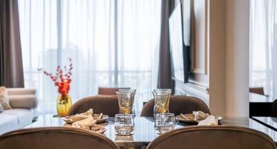 Elegant dining area with a table set for four, adjacent to a cozy living room