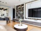 Modern living room with wall-mounted TV, open kitchen, and stylish shelving unit