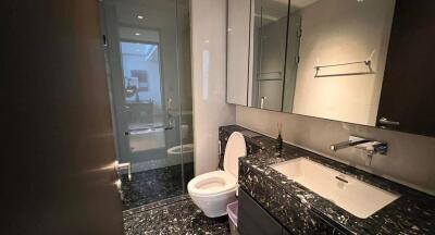 Modern bathroom with black marble countertop and glass shower