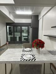 Modern dining area with marble table and vibrant red flowers