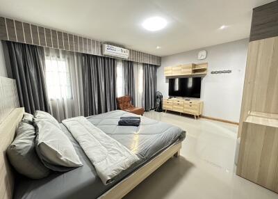 Modern bedroom with a large bed, TV, and storage units