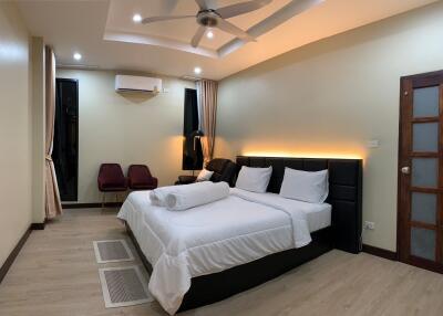 Modern, well-lit bedroom with double bed and seating area