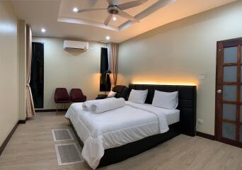 Modern, well-lit bedroom with double bed and seating area
