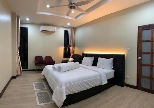 Modern, well-lit bedroom with double bed and seating area