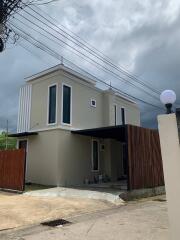 Modern two-story house with large windows and gated driveway