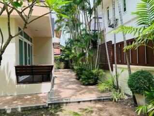 Outdoor view with greenery and connecting pathway between buildings