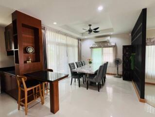 Modern dining area with large windows and ceiling fan