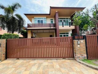 Exterior view of a modern two-story house with a front gate