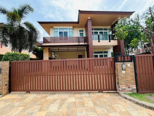 Exterior view of a modern two-story house with a front gate