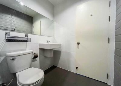 Modern bathroom with toilet, sink, and large mirror