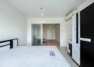 Spacious and well-lit bedroom with a bed, wardrobe, and air conditioning unit