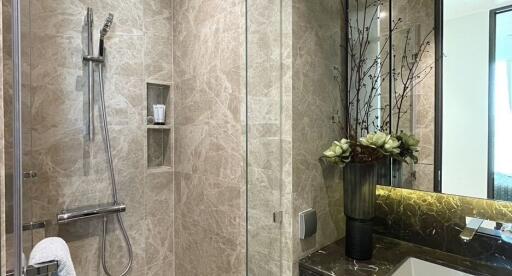 Modern bathroom with marble walls and a glass shower enclosure