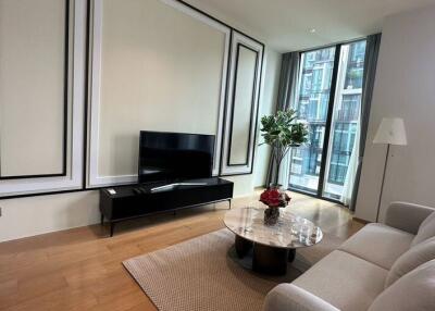 Modern living room with a large window, flat-screen TV, and comfortable sofa