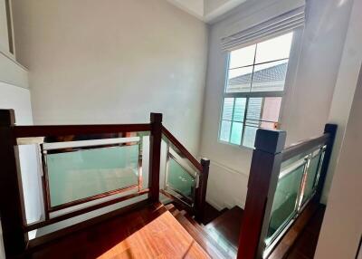 Well-lit wooden staircase with modern railing