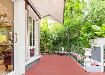 Beautifully landscaped outdoor patio area with a red floor, lush greenery, and decorative elements.
