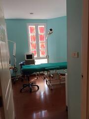 A clinic room with medical equipment and an examination table