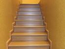 staircase with wooden steps and yellow walls