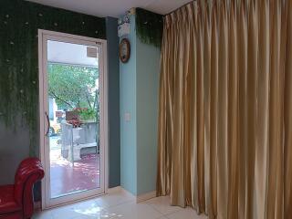 Living room with a couch, large window, and curtains