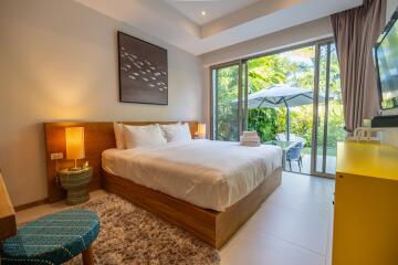 cozy bedroom with large glass doors leading to a lush backyard