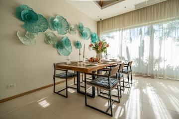 Modern dining room with decorative wall art, large windows, and elegant dining table setup