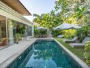 Modern outdoor area with pool, lounge chairs, and lush garden