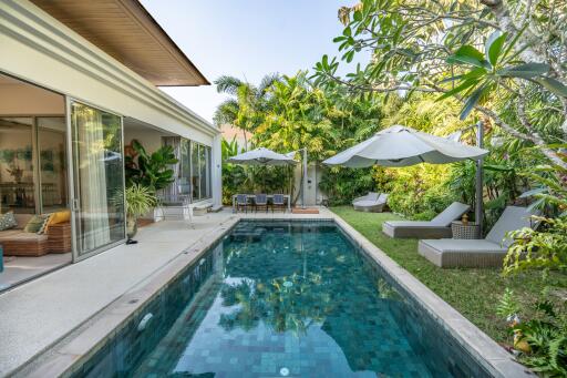 Modern outdoor area with pool, lounge chairs, and lush garden