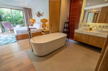 Spacious bedroom with ensuite bathroom featuring a modern bathtub