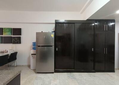 Modern kitchen with fridge, water dispenser, and cabinet storage