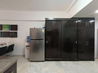 Modern kitchen with fridge, water dispenser, and cabinet storage