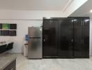 Modern kitchen with fridge, water dispenser, and cabinet storage