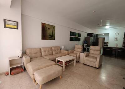 Spacious living room with beige seating and artwork on the walls