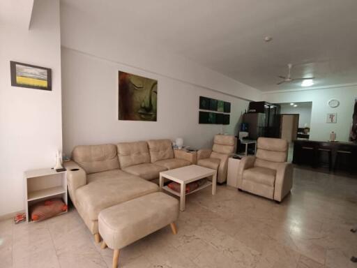 Spacious living room with beige seating and artwork on the walls