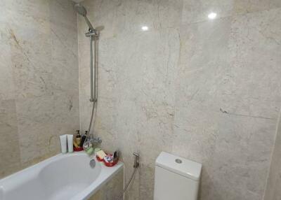 Marble-tiled bathroom with bathtub and shower
