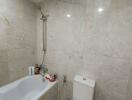 Marble-tiled bathroom with bathtub and shower