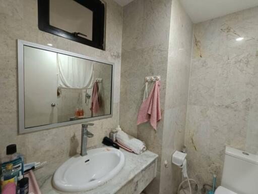 Modern bathroom with marble tiles and a wall-mounted mirror